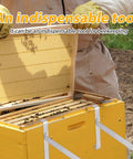 Beekeeper using Two Pack Stainless Steel Beehive Frame Holders For Beekeeping, 5 Frame Capacity Frame Perches on yellow hive.