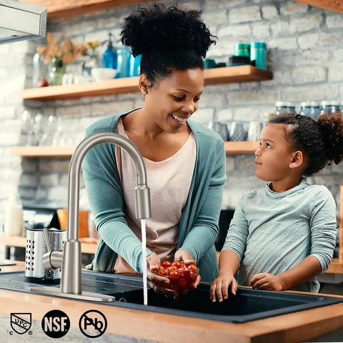 Smooth Operator Brushed Nickel Kitchen Faucet With Pull Down Sprayer Providing Three Versatile Flow Settings And A Flexible Swivel Spout For No Sweat Cleaning in use with a mother and daughter.