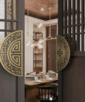 Decorative wooden door with ornate gold circular handle partially open, revealing a dining room interior