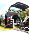 Heavy Duty Aluminum Handicap Parking Sign Ada Compliant Reflective Metal Plaque next to wheelchair van with ramp.