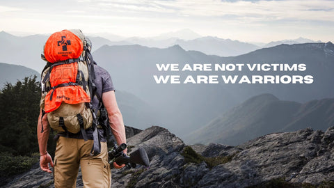 Backpacker with bright orange Warrior Kid Medic backpack on rocky mountain ridge.
