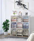 9 Cube White Storage Organizer Set in a living room, holding folded clothes and decor, near a plant and artwork on the wall
