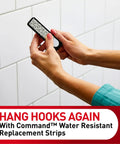 Person holding a water-resistant replacement strip against bathroom tile. Replacement Bath Strips Set With 2 Medium And 4 Large Water Resistant Adhesive Strips For Rehanging Bath Hooks Or Caddies No Tools No Residue Easy Removable In Hot Wet Humid Bathrooms.