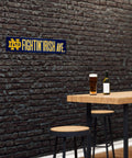 Notre Dame Fighting Irish 16 Inch Plastic Street Sign Wall Decor on brick wall with beer and stools, perfect for tailgating.