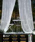 Curtain Fairy Lights With Remote, 300LEDs White Waterproof String Lights draped behind outdoor table and chairs, with 8 modes.