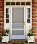 Tough As Nails Brass Storm And Screen Door Handle Set With Solid Lock and Key on a white storm door with flowers.