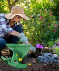 Gardener using Effortless Hand Crank Seed Spreader 1.5L for planting in a colorful flower bed
