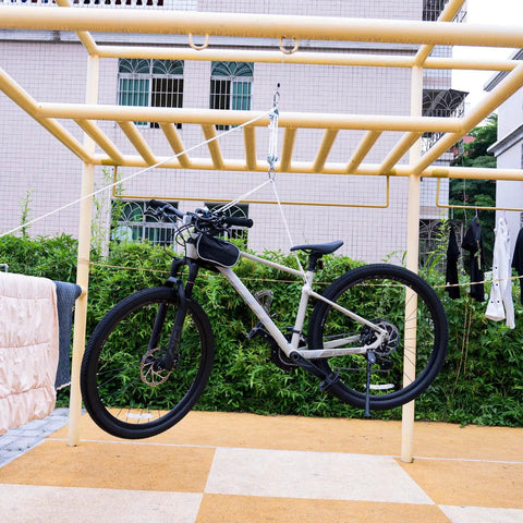 Double Snatch Block And Tackle Pulley System With Thirty Two Feet Of One Quarter Inch Rope And Hook hanging a bike in an outdoor rack