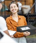 Woman holding a package with Self Seal Poly Mailers 14.5 X 19 Inch 100 Pack Tearproof Shipping Bags in black envelope