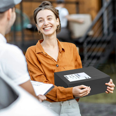 Woman holding a package with Self Seal Poly Mailers 14.5 X 19 Inch 100 Pack Tearproof Shipping Bags in black envelope