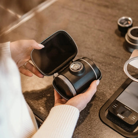 Person holding Picopresso Portable Espresso Maker Bundle With Protective Case for pro level coffee on the go.