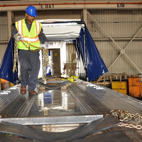 Worker securing cargo on flatbed with Binder Chain With Grab And Sling Hooks Grade 70 Standard Duty Three Eighths Inch By Eight Foot 6600 Pound Safe Working Load Heavy Duty Cargo Tie Down For Trucks Trailers And Flatbeds