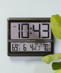 Huge Wireless Atomic Clock With Indoor And Outdoor Temperature, Humidity, Date, Day Of Week, And Automatic DST Adjustments, NIST Radio Controlled Time With Easy Setup For Home Or Office, wall-mounted view with time, temperature, and date displayed.
