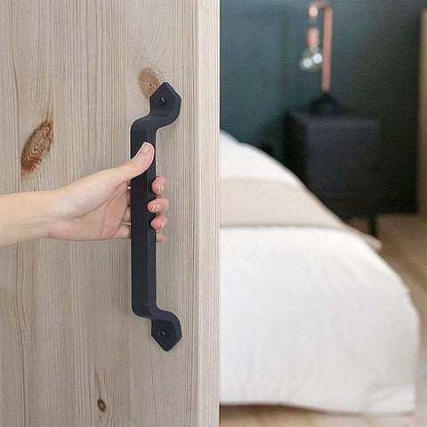Person holding Barn Door Handle Set Eleven And One Eighth Inch Built Tough Rustic Cast Iron Gate Pulls In Black on wooden door