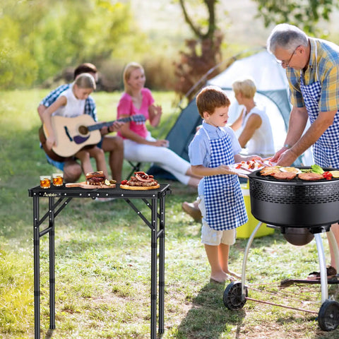 Folding Grill Table For Camping And BBQ, Aluminum Outdoor Table with adjustable height, holding food next to family campfire scene, 22.8x16 in, Black.