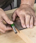 Hands using All In One Credit Card Diamond Sharpening Kit With 180 300 Grit And 600 1000 Grit Stones on a wooden surface.