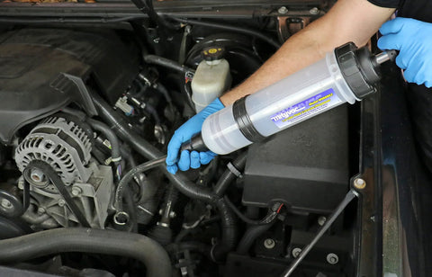 Mityvac MVA6852 1.5L fluid evacuator syringe, side view in engine bay with blue-gloved hand