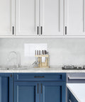 Modern kitchen with Matte Black Cabinet Knobs Set 10 Pack Durable Zinc Alloy Single Hole Cabinet Handles on white and blue cabinets