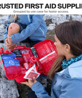 SurviveX large first aid kit in red zippered case opened to reveal bandages and wound-care supplies