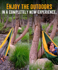 Two people in Cozy Two Person Camping Hammock With Bug Net And Rain Fly, lounging by a stream in a forested area.