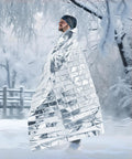 Person in snowy landscape wrapped in Mylar Emergency Blankets Space Blanket Thermal Survival Gear For Camping And Outdoors Hiking Bug Out Bags And First Aid Kits Lightweight Durable Mylar Blanket For Cold Weather Auto And Home Prep.