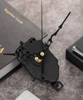 DIY Quartz Clock Movement Kit Replacement Mechanism With 0.9 Inch Pendulum Rod on a book with ornate black hands.