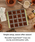 SuperSeed All In One Seed Starting Tray With 16 XL Cells on wooden table, surrounded by gardening tools and pots, reusable and dishwasher safe.