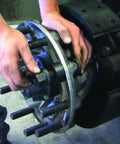 Mechanic using Truck Wheel Stud Installer Tool for 22mm studs with impact wrench on heavy-duty vehicle wheel