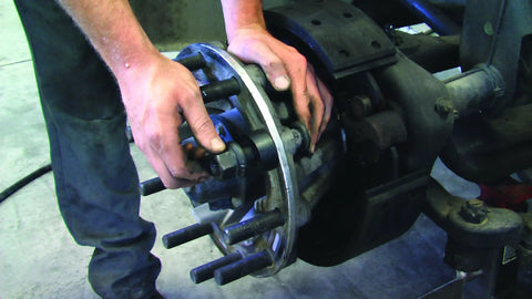 Mechanic using Truck Wheel Stud Installer Tool for 22mm studs with impact wrench on heavy-duty vehicle wheel