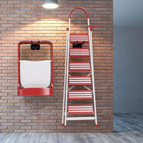 Foldable ladder with red and white steps mounted on brick wall, showcasing storage solution