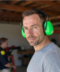 Man wearing Professional Safety Ear Muffs With 37 dB NRR For Shooting And Industrial Use, showing comfort fit and cushioned headband.
