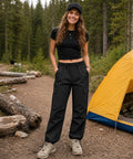 Woman standing in forest wearing Women's Cargo Hiking Pants With Elastic Waist, Water Resistant Quick Dry Parachute Style Baggy Fit, Black Size M