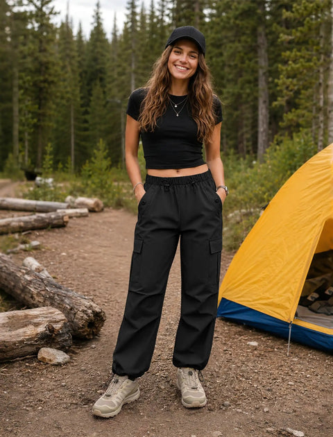 Woman standing in forest wearing Women's Cargo Hiking Pants With Elastic Waist, Water Resistant Quick Dry Parachute Style Baggy Fit, Black Size M