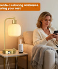 Woman enjoying a book next to an Industrial Touch Control Desk Lamp With Dual USB Ports And Outlet For Charging Up Fast 3 Way Dimmable Bedside Nightstand Reading Lamp Glass Desk Lamp For Bedroom And Office.