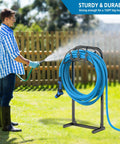 Person using Built Tough Garden Hose Holder Freestanding Metal Hose Stand With 4 Spikes Holds Up To 150 Ft Of Hose in lawn