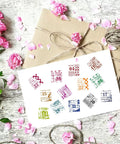 Vintage Date Clear Stamps Top Shelf Seal Set with colorful numbers on white card beside a gift wrapped in brown paper.
