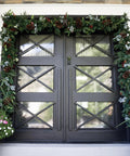 Heavy Duty Adjustable Front Door Garland Hanger With Padded Ends Providing Rock Solid Grip On Jambs From 51 To 81 Inches Holding 20 Lbs Of Decor For Zero Stress Holiday Setup on a decorated black door.