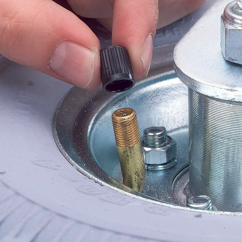 Person installing air valve cap on Smooth Rollin Pneumatic Wheel Caster Set Featuring Two Rigid And Two Swivel Units With Bully Proof Eight Inch Tires And Protective Donut Bumpers Perfect For Heavy Duty Carts And Warehouse Moves.