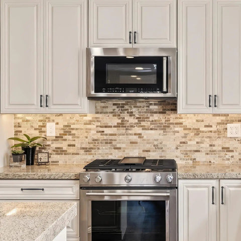 Modern kitchen featuring sleek matte black cabinet handles for drawers, stylish stone backsplash, and stainless steel appliances.