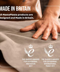 Person's hand touching fabric with text 'Made in Britain' and awards for innovation and trade, showcasing UK-made products.