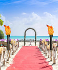 Beach wedding setup with Realistic Flameless LED Torch Light Prop Lamp For Parties, Holidays, Patio Decor, on sandy pathway