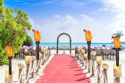 Beach wedding setup with Realistic Flameless LED Torch Light Prop Lamp For Parties, Holidays, Patio Decor, on sandy pathway