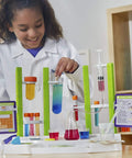 Child using Ooze Labs Chemistry Station Science Kit for Kids with 57 Pieces and 20 Safe Experiments at home, smiling with lab setup