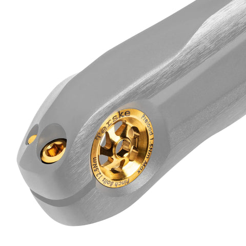 Close-up of Titanium Crank Upgrade Kit For Shimano Mountain And Gravel Bikes With Gold Preload Cap And Bolts, lightweight titanium.