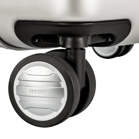 Close-up of DELSEY spinner wheel on silver hardside luggage with black wheel housing