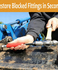 Hands using Grease Fitting Cleaning Tool No More Clogged Zerks Zerk Buster on machinery, universal fit, red handle, outdoor maintenance scene