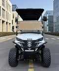 White Electric Golf Cart Featuring Fourteen Inch All Terrain Tires And Spacious Kick Back Seating Built Tough For Smooth Cruising parked in urban street.
