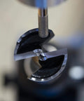 Pro Grade Forstner And Hinge Boring Bit Sharpener showing a finely sharpened drill bit ready for use.