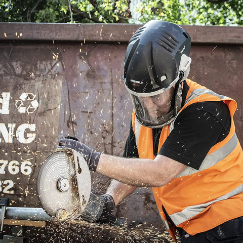 Worker using grinder with Airshield Pro Respirator and Face Shield Bundle With Extra Battery Charging Cradle and Eight Hour Rechargeable Battery For All Day Comfort Bearded Friendly PPE Kit With Spare Six Hour Battery and Long Wear Protection in workshop