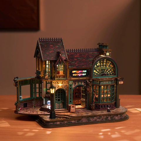 3D Wooden Puzzle Bookstore With LED Lights Spellbound Miniature Kit for DIY home decor on a table, glowing warmly.